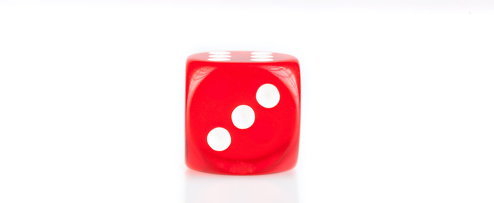 Red die with three dots showing.