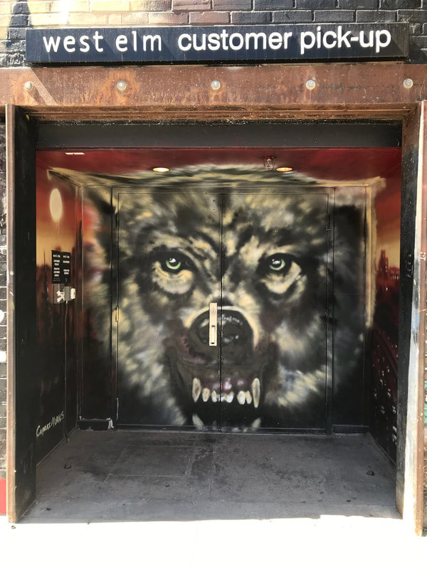 Street art in Boise's Freak Alley: Large face of menacing wolf on a set of double doors.